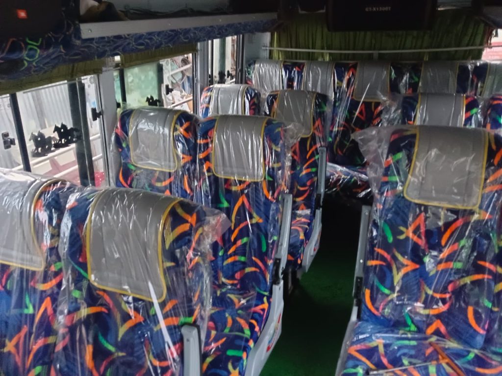 Bus interior with curtains and overhead monitor